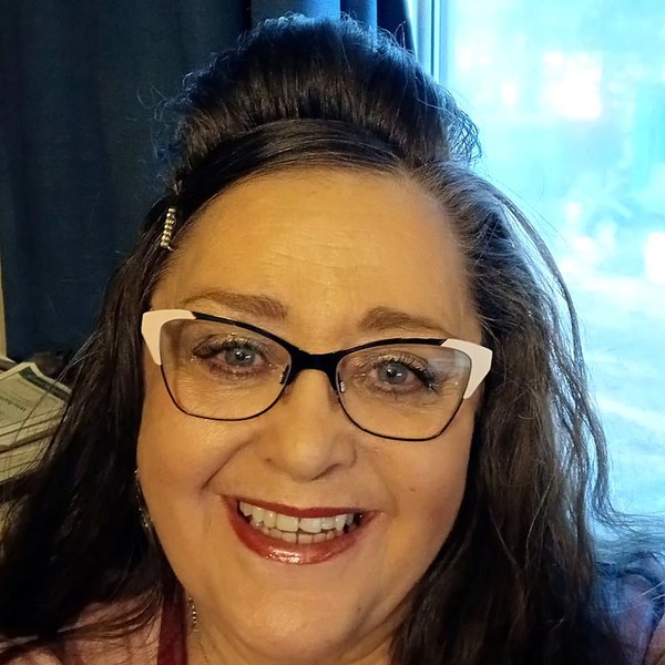 Mary J.C., smiling, wearing glasses